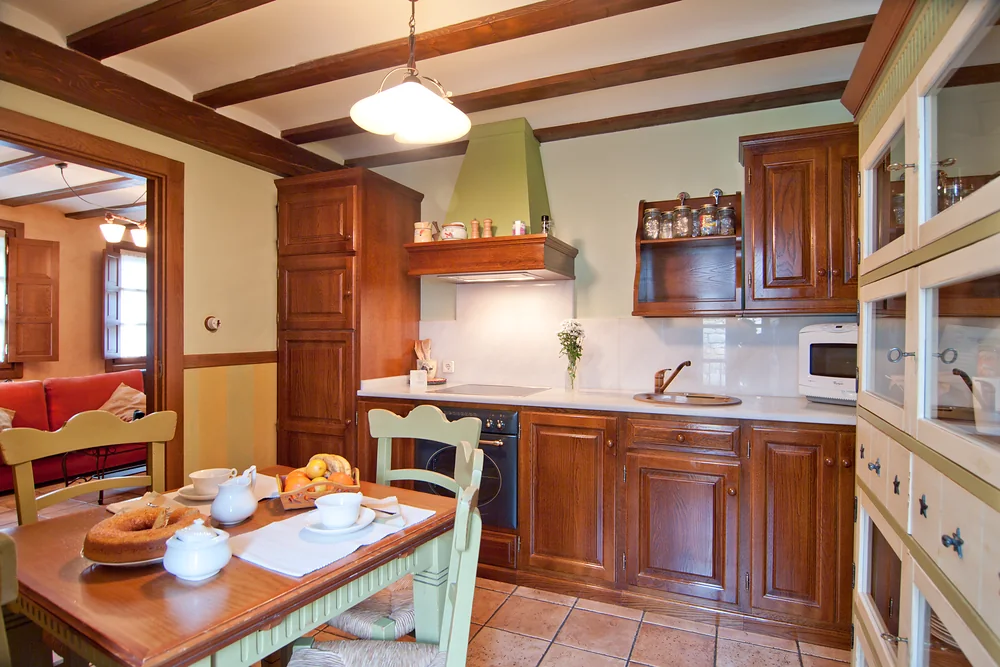 Cocina con muebles de madera y mesa de comedor